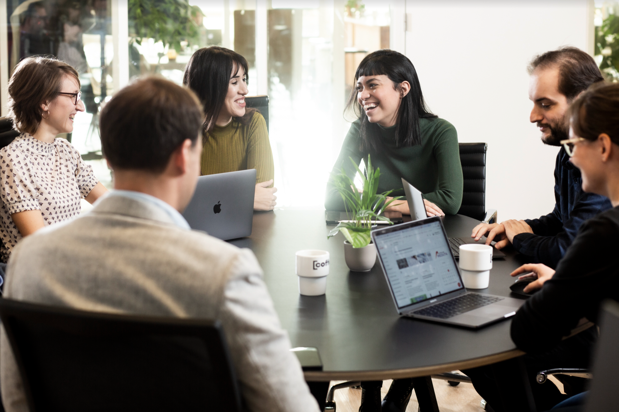 Chainels employees laughing and working around a table