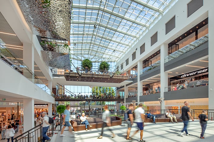 Shot of indoor shopping centre with shoppers walking around in it